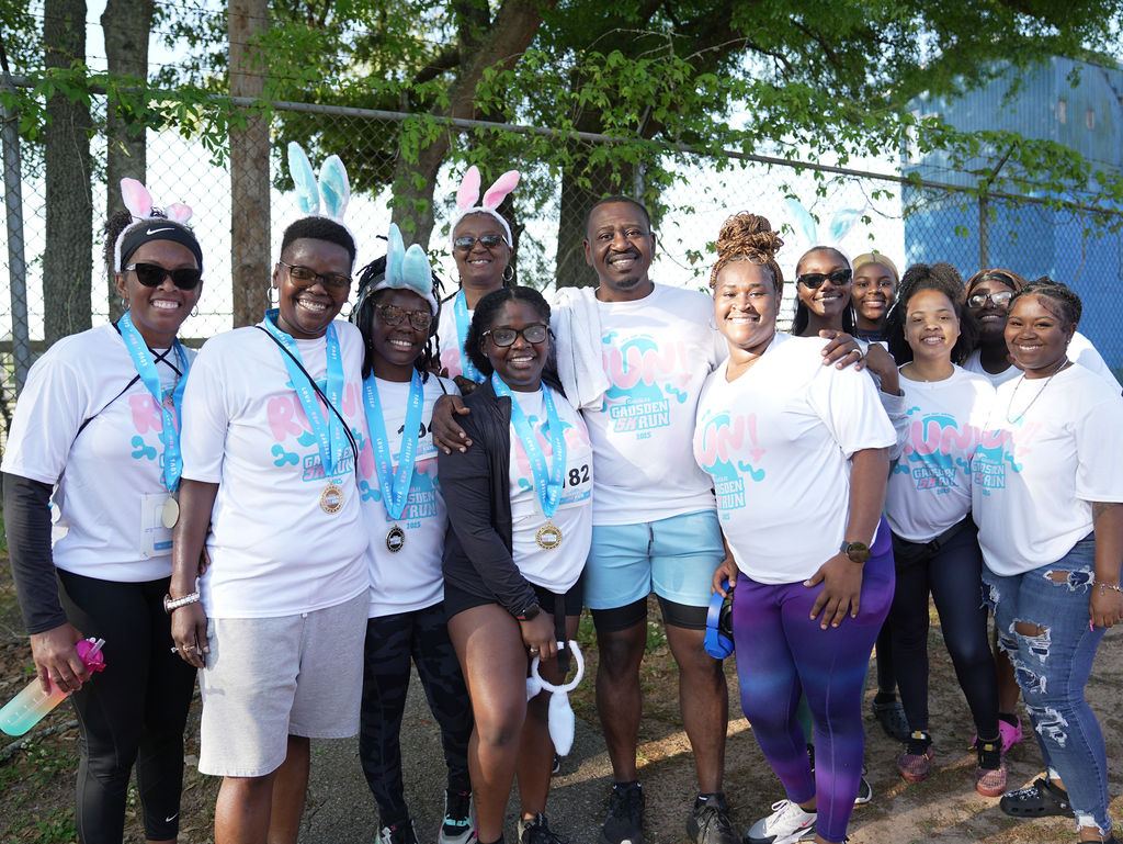 A big group of smiling 2025 participants posing together after the run