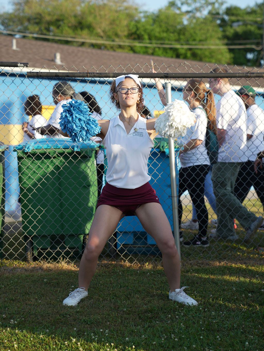 A cheerleader mid-jump hyping up the runners