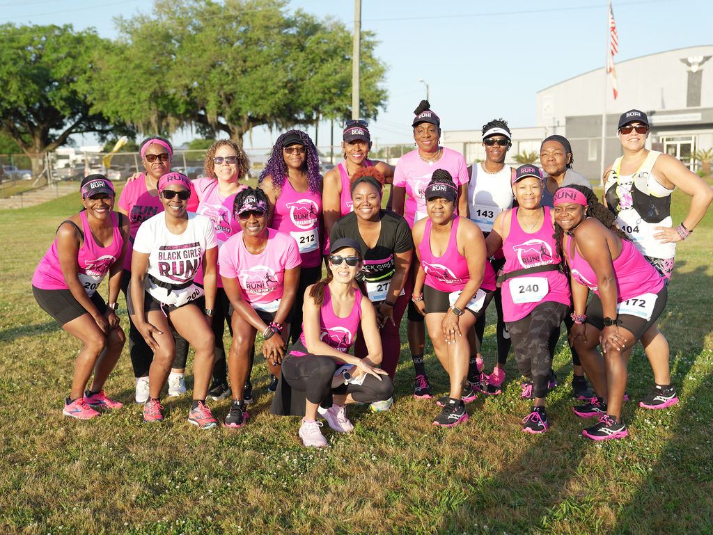 A running crew in bright pink posing before the 2025 race