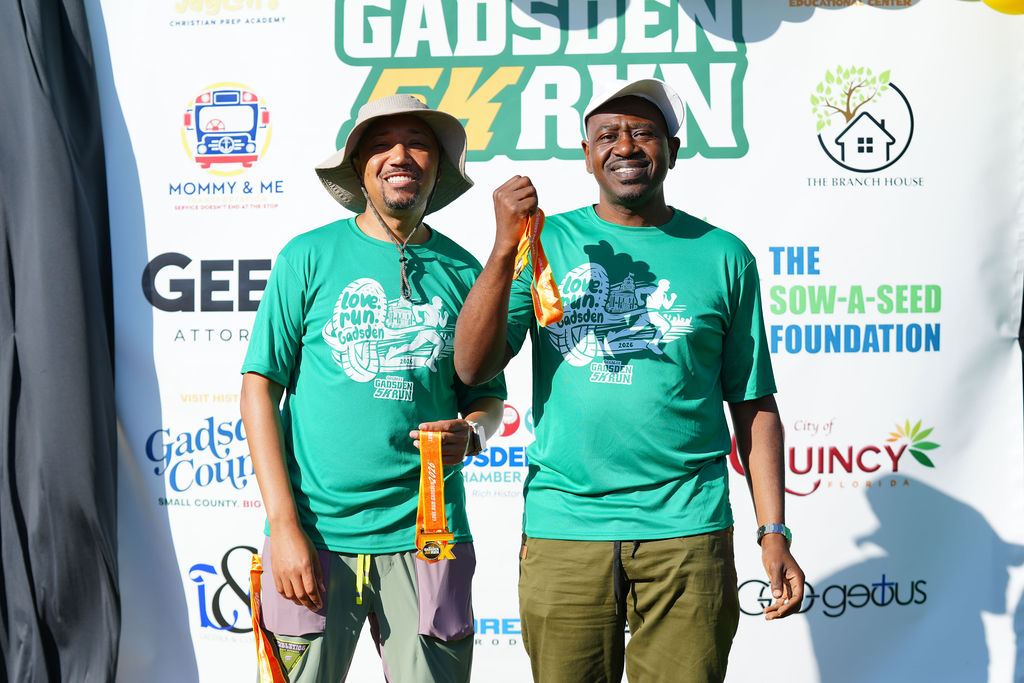 Finishers posing at the Gadsden 5K photo backdrop in 2026