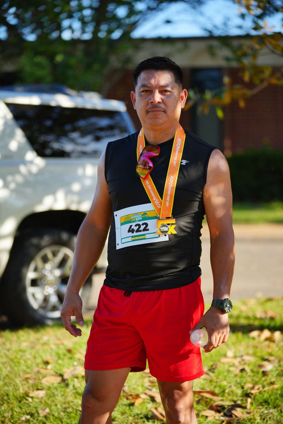 A runner standing proudly with his finisher medal in 2026