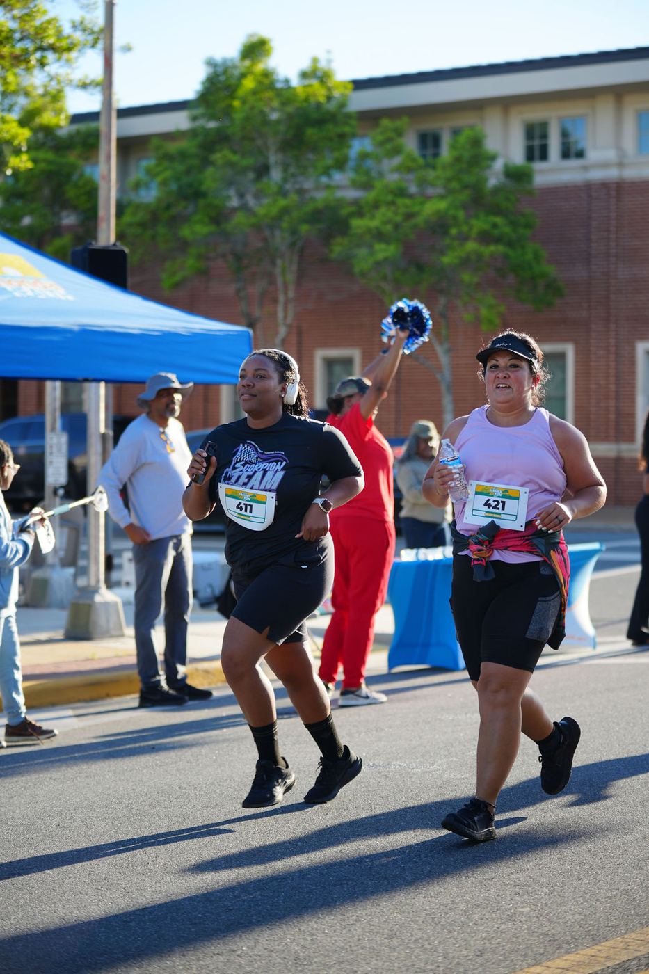 Two runners keeping pace together through downtown Quincy in 2026